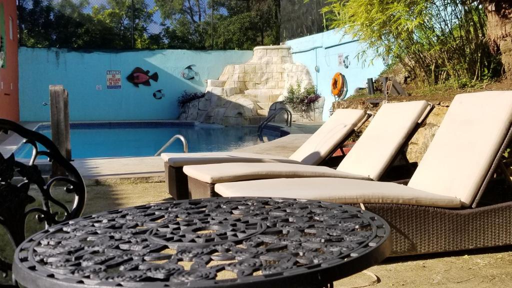 a group of chairs and a table in front of a pool at Altamont West Hotel in Montego Bay