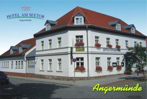 a large white building with a red roof at Hotel am Seetor in Angermünde