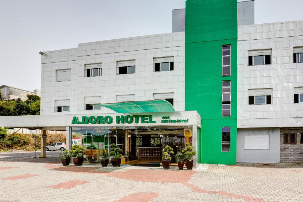 um hotel com um edifício verde e branco em Adoro Hotel em Farroupilha