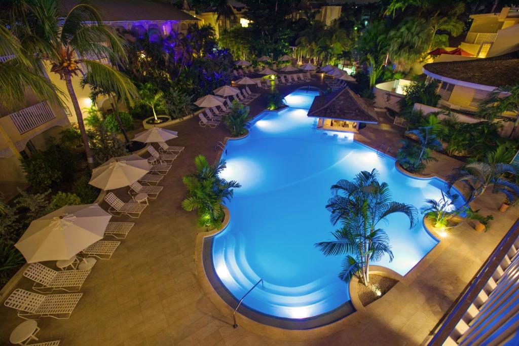 an overhead view of a large swimming pool with umbrellas at Sugar Bay Barbados - All Inclusive in Bridgetown