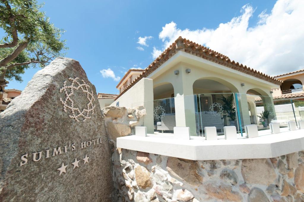 a building at the resort with a stone wall at Suimi's Hotel in Villasimius