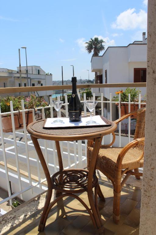 a table with a bottle of wine and glasses on a balcony at Il Gabbiano in Otranto