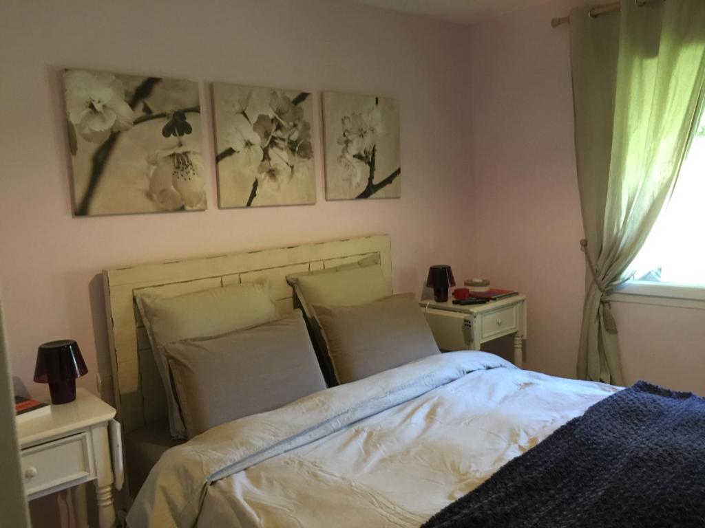 トレギエにあるAux Perderiesのベッドルーム1室(ベッド1台、テーブル2台、窓付)