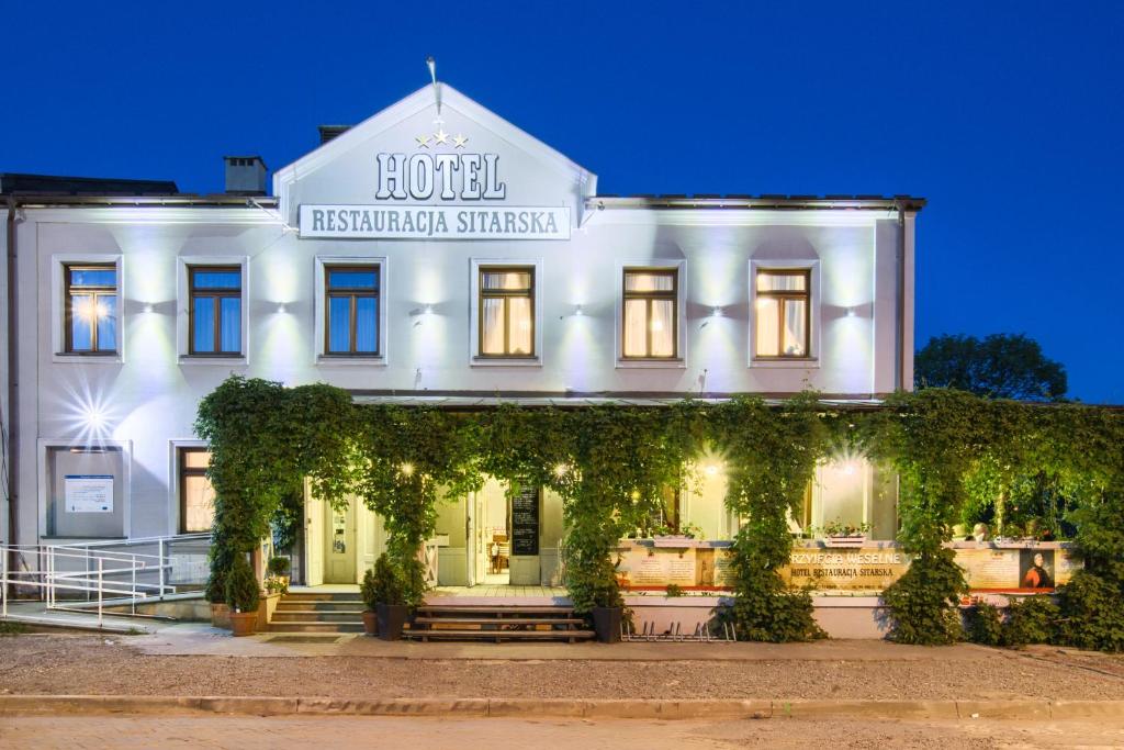 ein weißes Gebäude mit einem Schild, das das Hotel interkontinentale Schweiz liest in der Unterkunft Hotel Sitarska in Biłgoraj