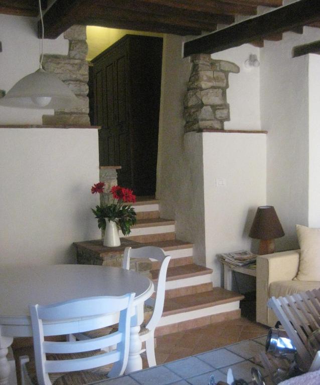 a living room with a table and chairs and stairs at Casa Vacanze del Borgo in Sassetta