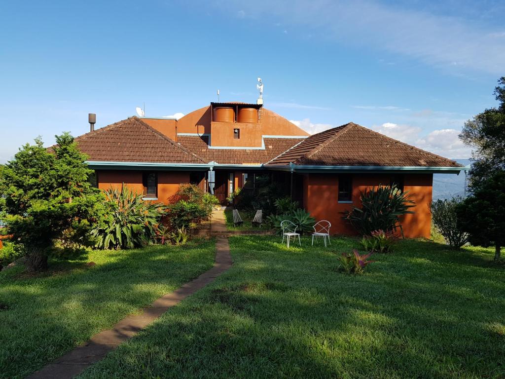 uma casa com um jardim de relva em frente em Estúdio dentro do Templo Budista em Três Coroas