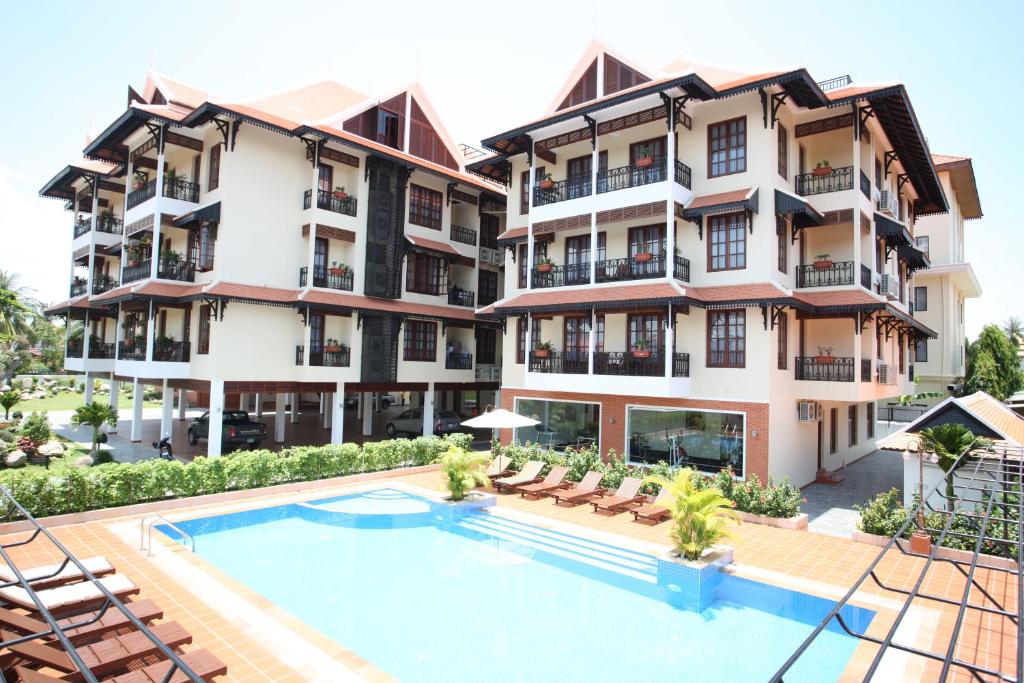 een appartementencomplex met een zwembad ervoor bij Templation Residence in Siem Reap