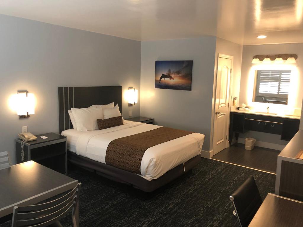 um quarto de hotel com uma cama e uma secretária em Pacific Inn Monterey em Monterey