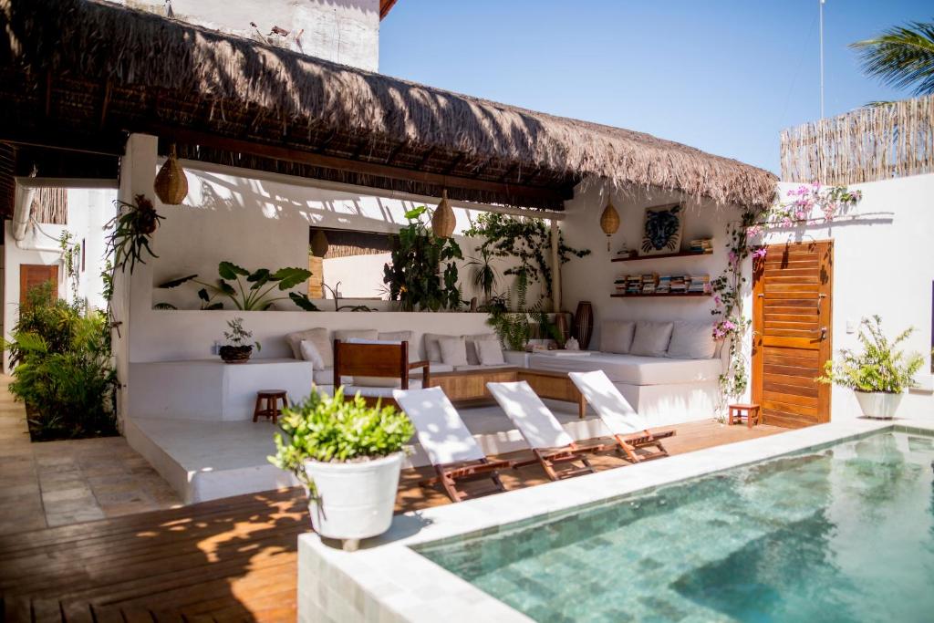 a patio with a swimming pool and a villa at Tropical House - Villa com piscina perto do mar in Jericoacoara