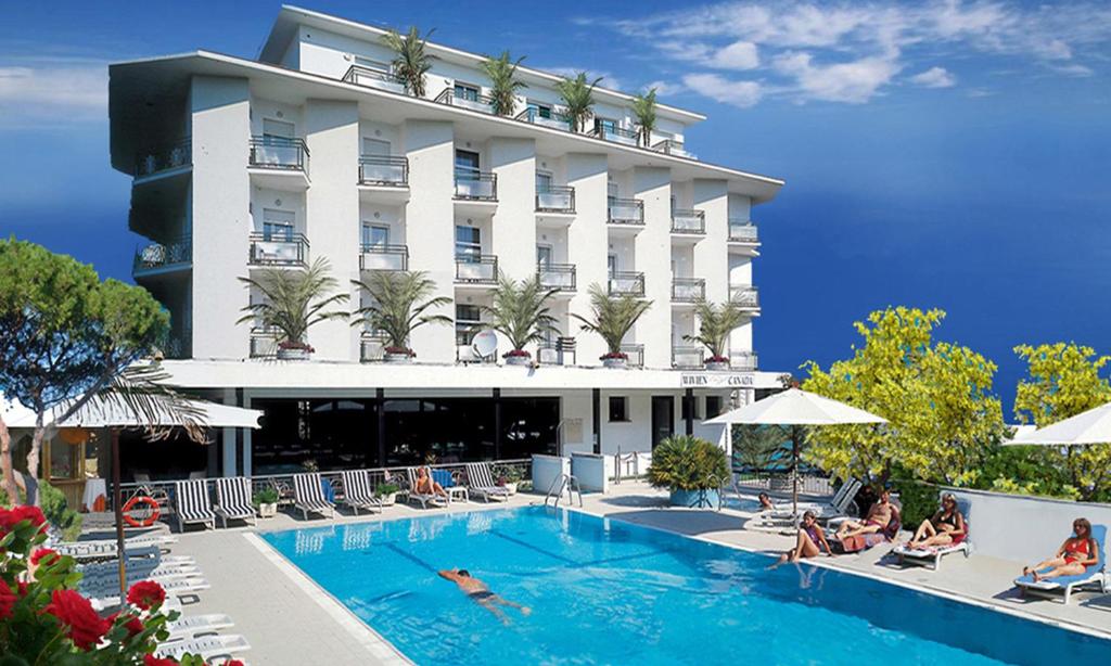 a hotel with a swimming pool in front of a building at Hotel Wivien in Cesenatico