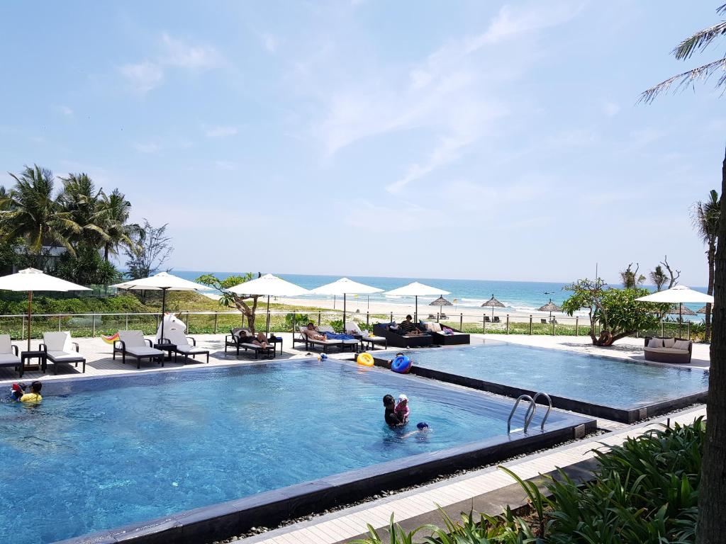 a person in a swimming pool next to the beach at Two Bedrooms Apartment with Sea View in Danang