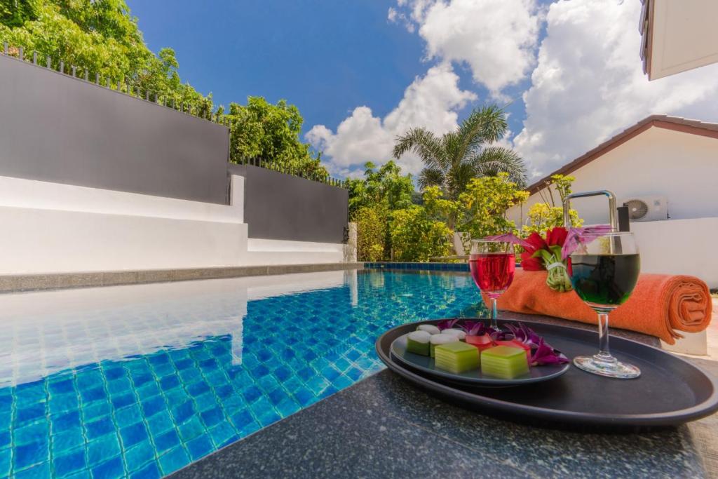 - un plateau de nourriture et de verres à vin à côté de la piscine dans l'établissement Star 2 BR Private Pool Villa - Chalong, à Chalong