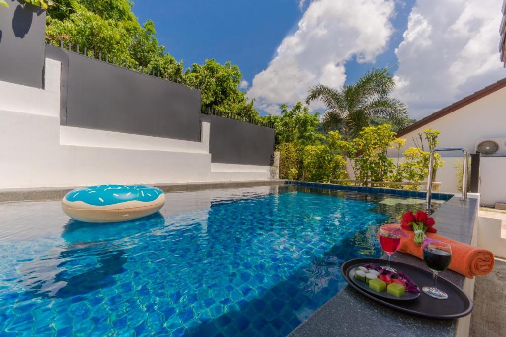 a swimming pool with a table with a plate of food on it at Chalong - 2 Bedroom Hideaway Private Pool Villa - Phuket in Chalong