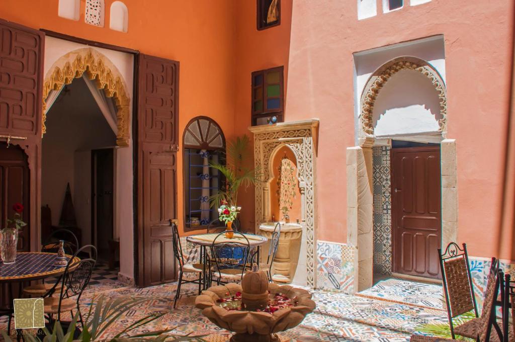 a courtyard of a building with a table and chairs at Riad Jbara in Rabat