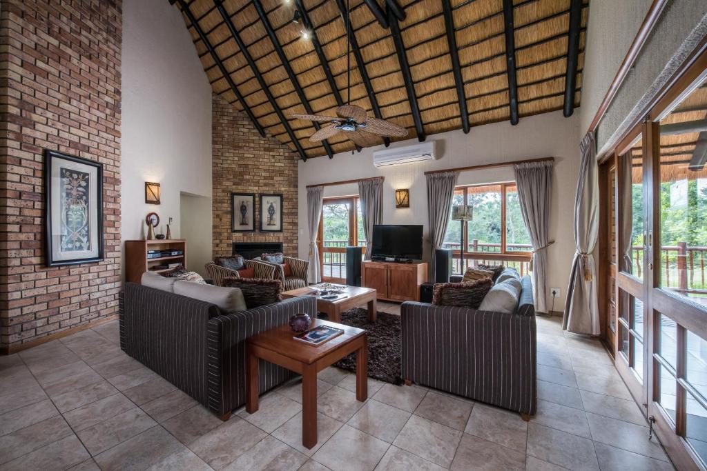 a living room filled with furniture and a brick wall at Kruger Park Lodge Unit No. 277 in Hazyview