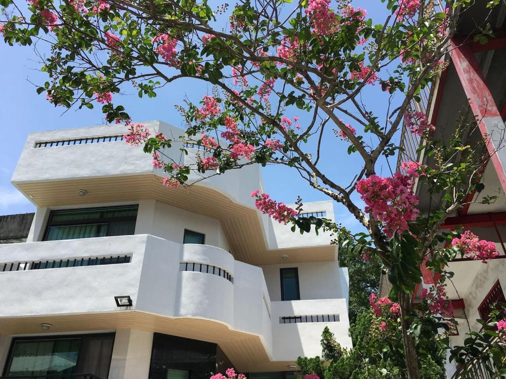 a building with pink flowers in front of it at Literature River Bank 文學河岸 禁菸小包棟民宿 in Hualien City