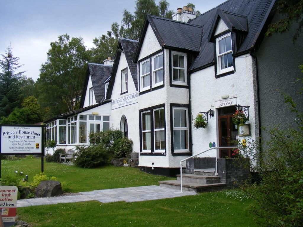 a white and blue house with a large window at The Prince's House Hotel in Glenfinnan