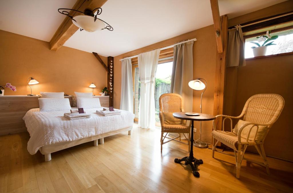 Schlafzimmer mit einem Bett, einem Tisch und Stühlen in der Unterkunft Absolut Oiseaux in Parisot