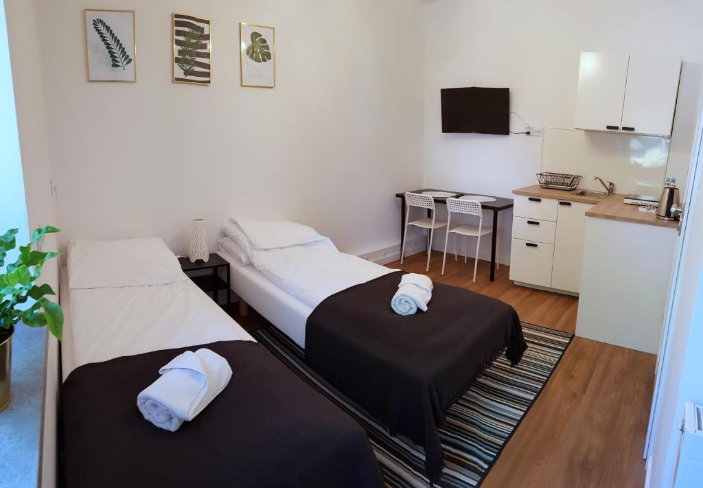 2 łóżka w małym pokoju z kuchnią w obiekcie Apartamenty METRO Targówek w Warszawie