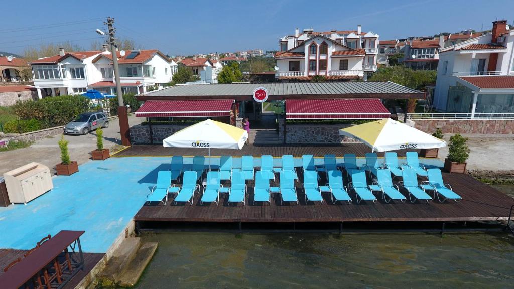 a swimming pool with chairs and umbrellas in the water at Ezer Hotel in Ayvalık