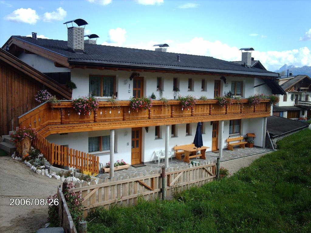 a large white house with a wooden balcony at Ferienwohnung Winklerhof in Maranza