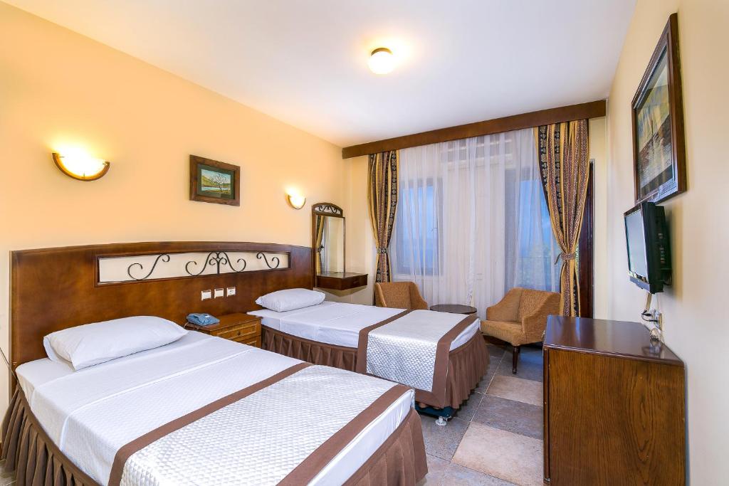 A bed or beds in a room at Hotel Club Phellos