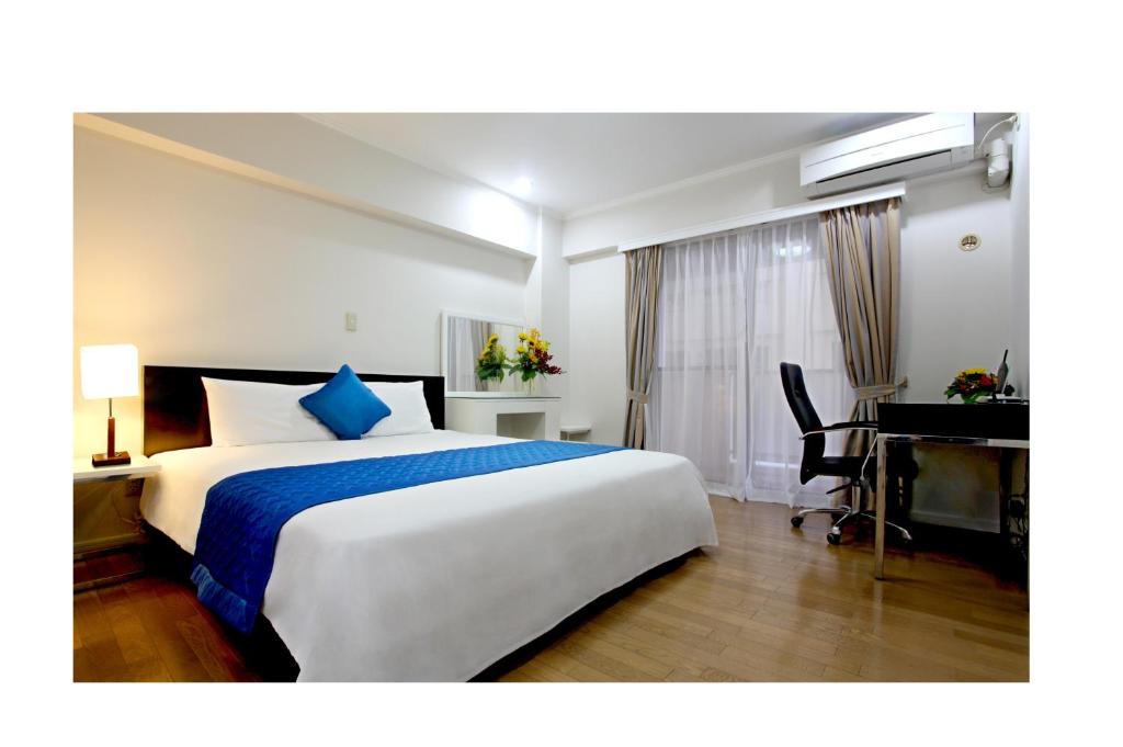 a hotel room with a large bed and a desk at Saigon Sky Garden Serviced Apartments in Ho Chi Minh City