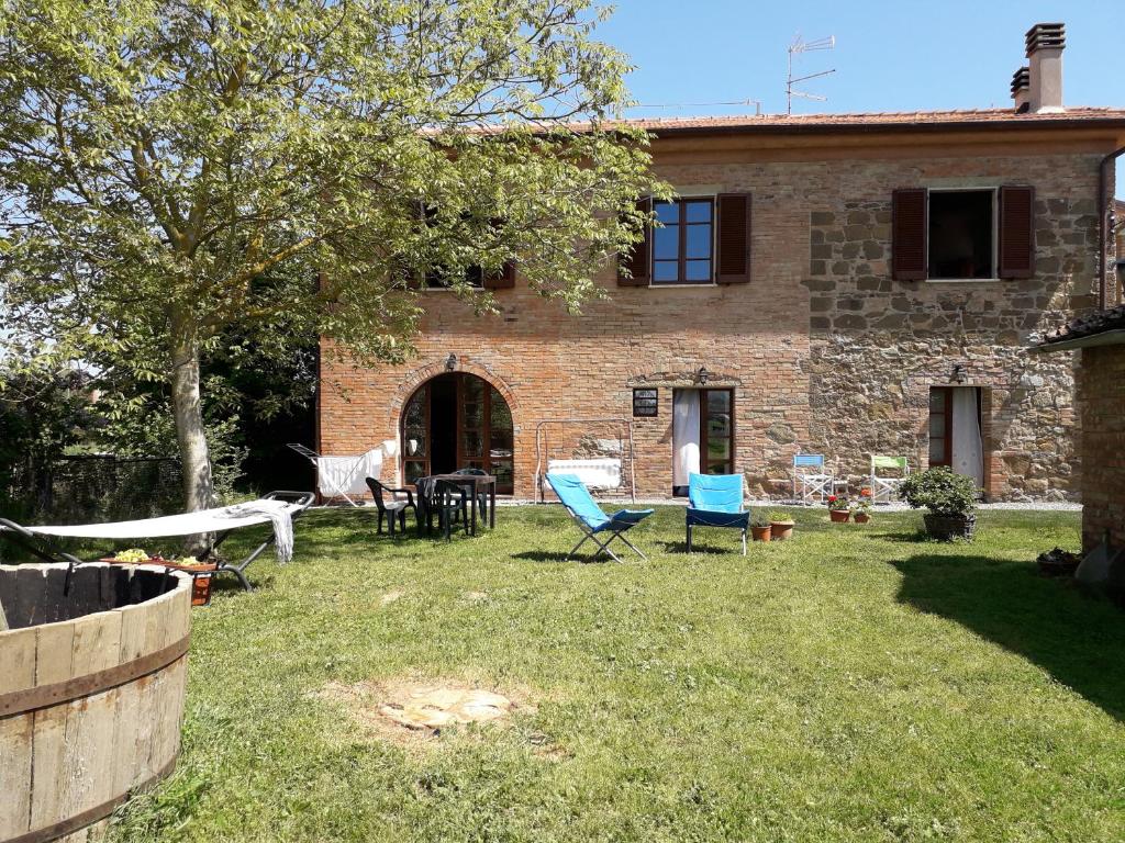 una casa con un patio con sillas y mesas en Podere Alberello en Torrita di Siena