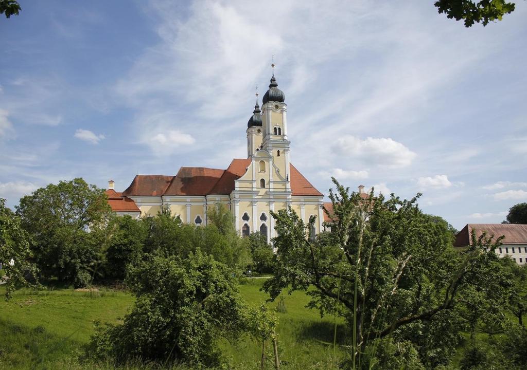 un gran edificio con una torre en lo alto de un campo en Klostergasthof Roggenburg en Roggenburg