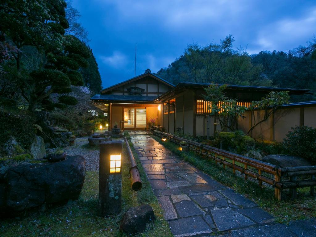a japanese house at night with a walkway at Ryori Ryokan Shikanoyu in Ena