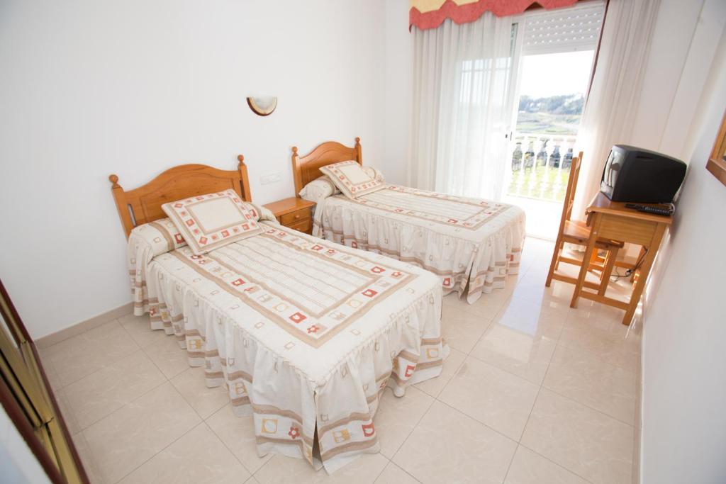 A bed or beds in a room at Casa Rodiño