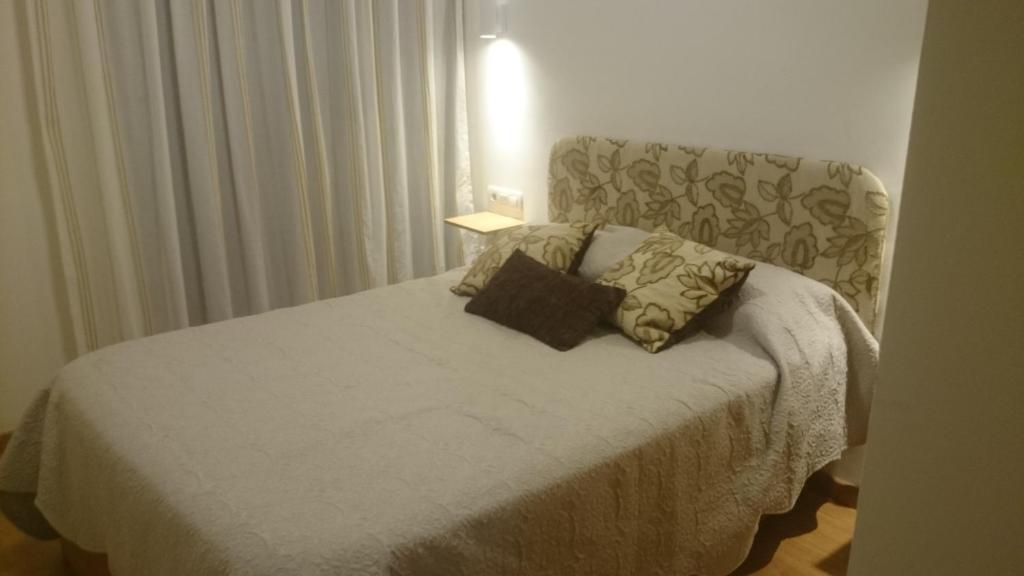 łóżko z dwiema poduszkami w pokoju w obiekcie Casa de George w Maladze