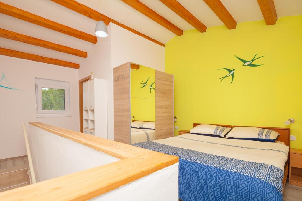 a bedroom with a bed and a yellow wall at Miramare in Pomer