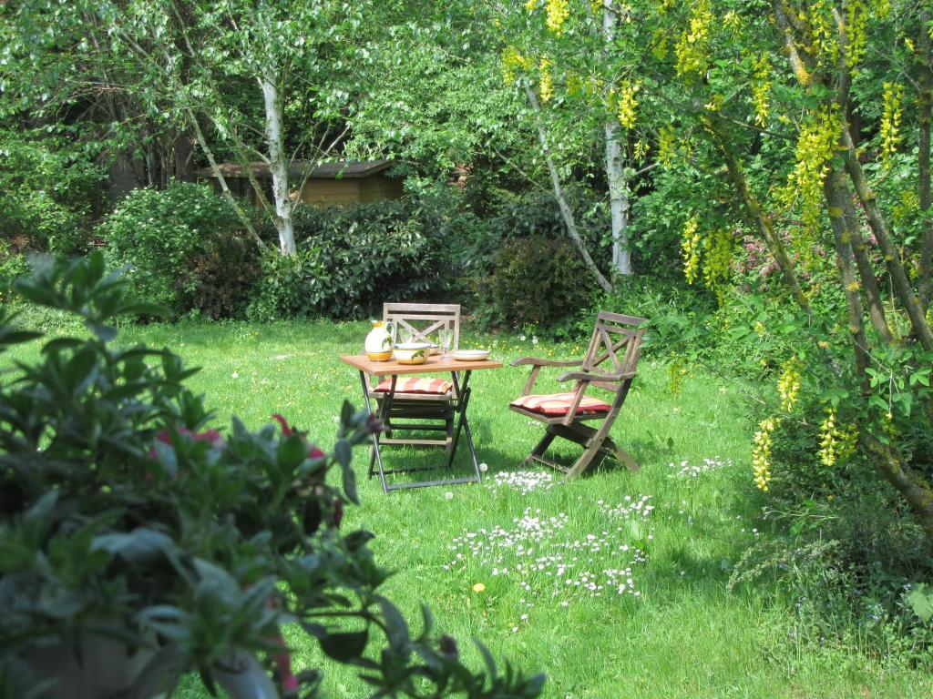 einen Tisch und zwei Stühle im Gras in der Unterkunft EIFEL Gästewohnung in Blankenheim