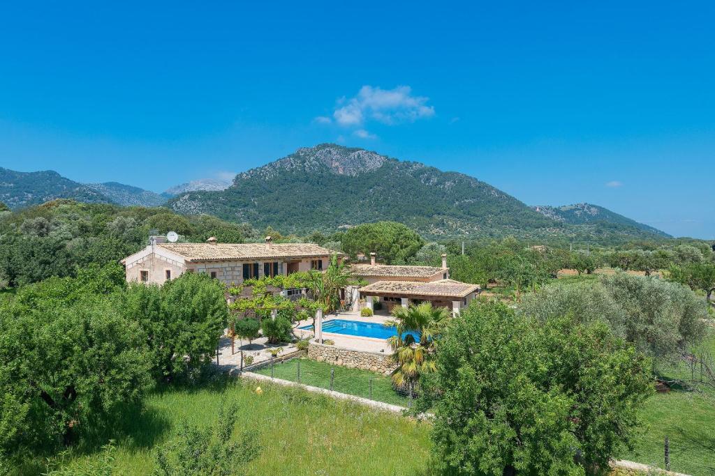 an aerial view of a house with a pool and mountains at Finca - Agroturisme Sa Parellada in Binibona