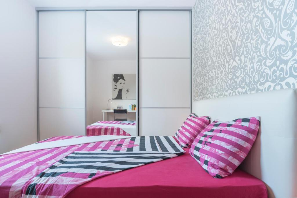 ein Schlafzimmer mit einem rosa Bett mit zwei Kissen in der Unterkunft Apartment Daniela in Malinska