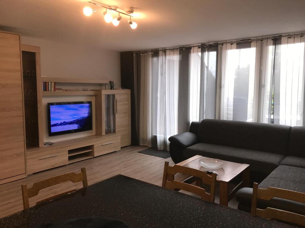 ein Wohnzimmer mit einem Sofa und einem TV in der Unterkunft Ferienwohnung im Terrassenpark Sasbachwalden in Brandmatt