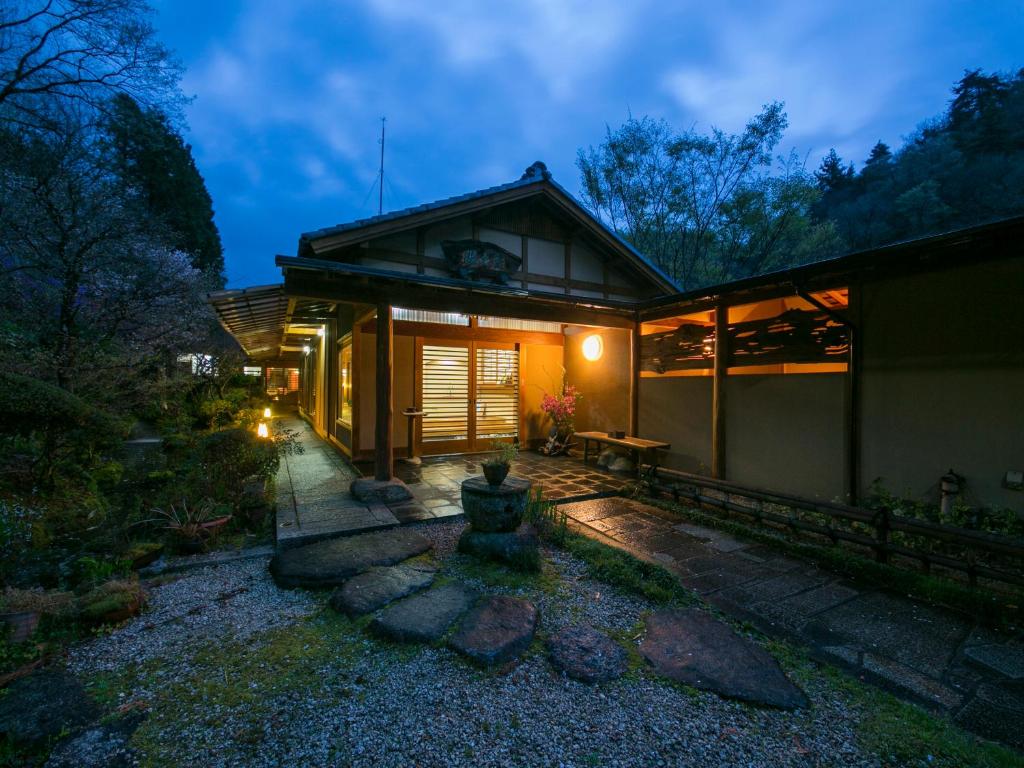 a home with a lit up front yard at night at Ryori Ryokan Shikanoyu in Ena
