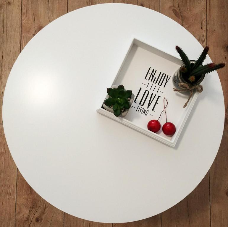 einem weißen Tisch mit einem Bild und einer Pflanze in der Unterkunft Pension BeOne in Trossingen