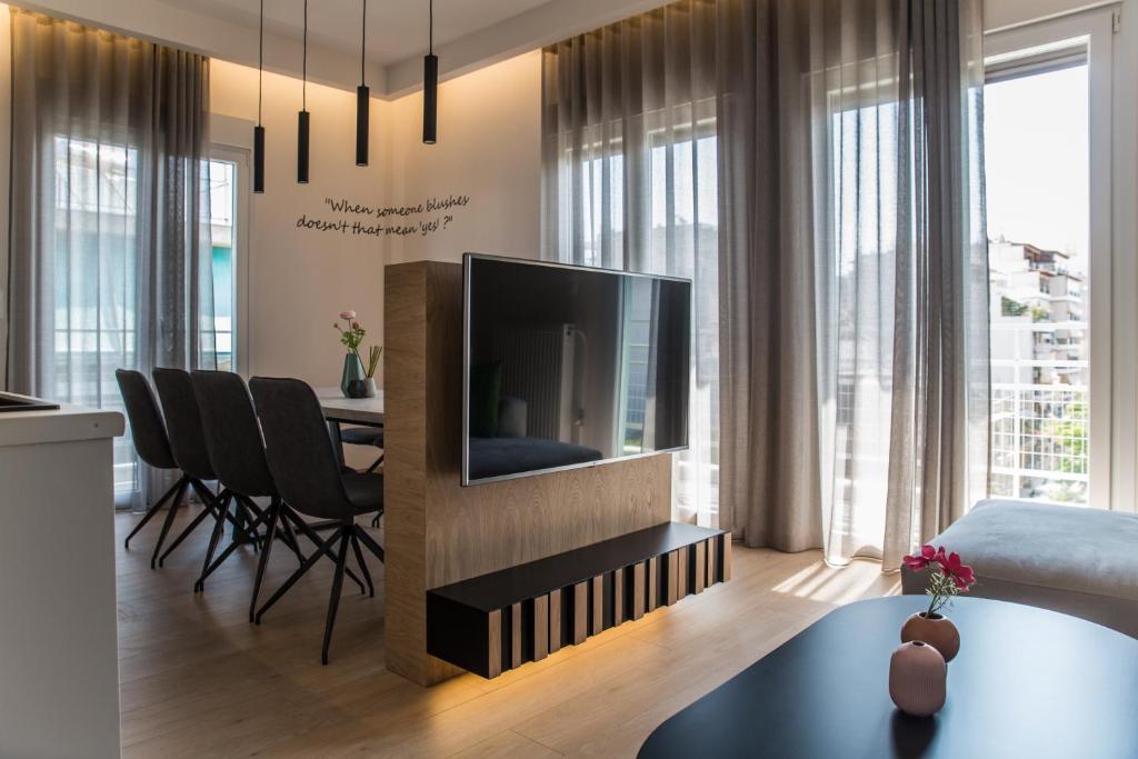 a living room with a television and a dining room at Athens Life in Athens