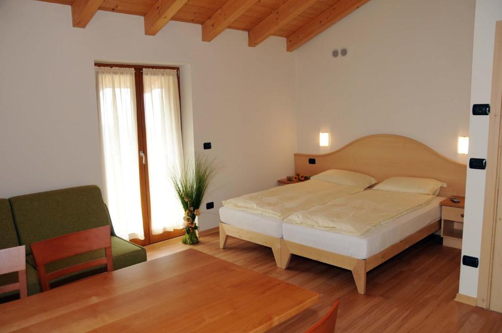sypialnia z łóżkiem i zielonym krzesłem w obiekcie Agritur alla Veduta w Trydencie