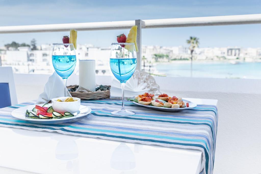 una mesa con dos copas de vino y comida en ella en Hotel Albània, en Otranto