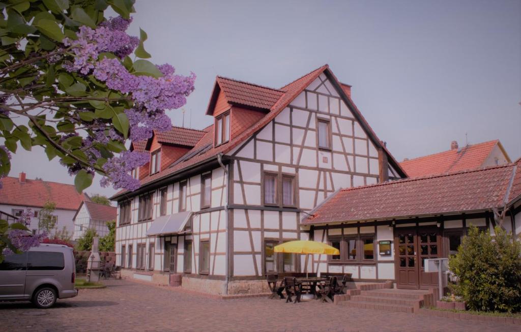 a building with a table and a yellow umbrella at Pension Ujut in Bad Langensalza