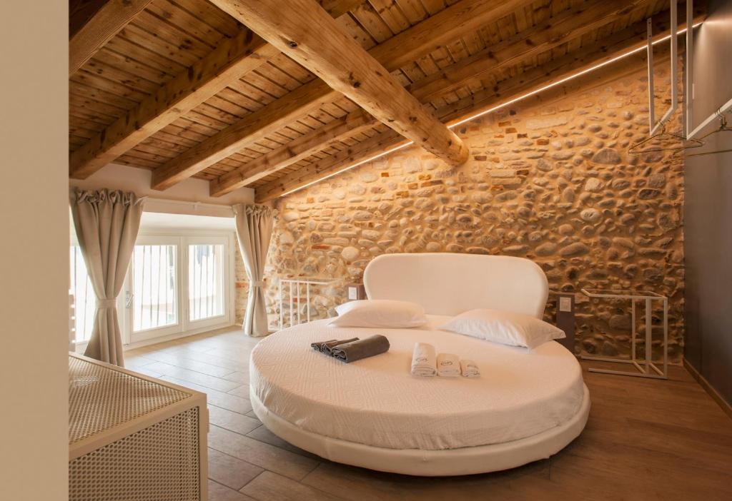 Habitación con una silla blanca en una habitación con una pared de ladrillo. en B&B La Bellavita del Garda Luxury, en San Felice del Benaco