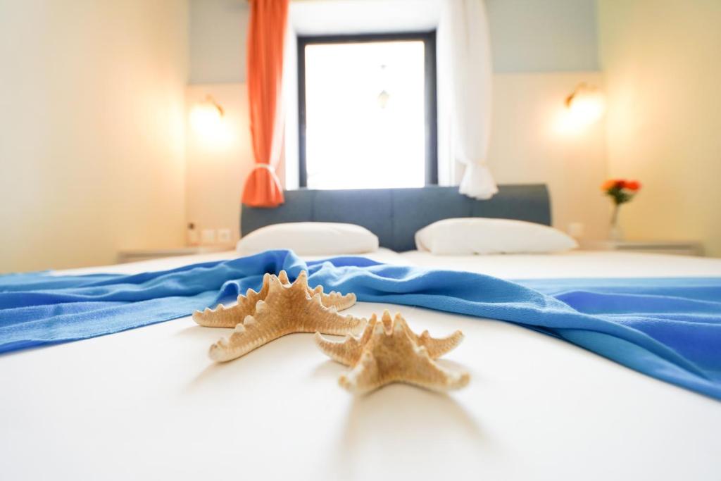 Dos estrellas de mar sentadas sobre una cama en Dionisos Palms Apartments, en Paralia Dionisiou