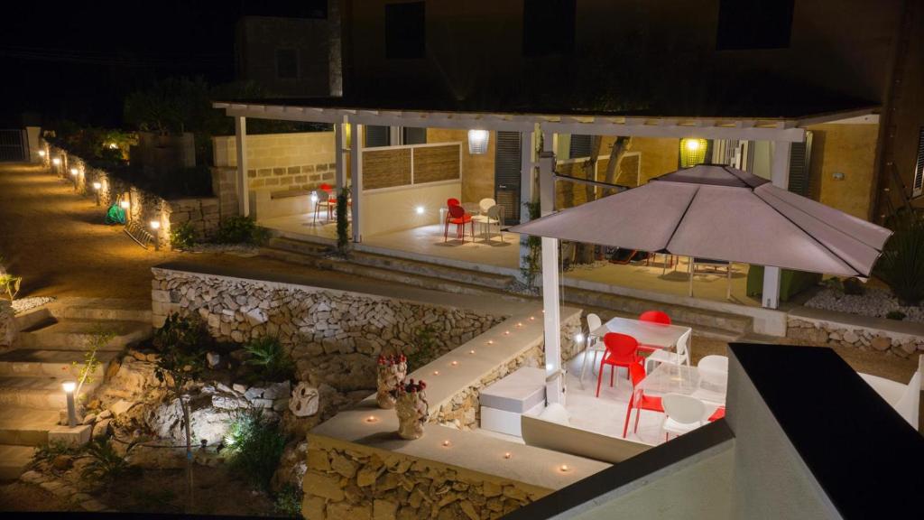 una casa con sombrilla, mesa y sillas en Le Suites del Carrubo en Favignana