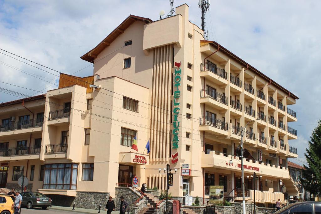 a building with a sign on the side of it at Hotel Ciucas in Vălenii de Munte