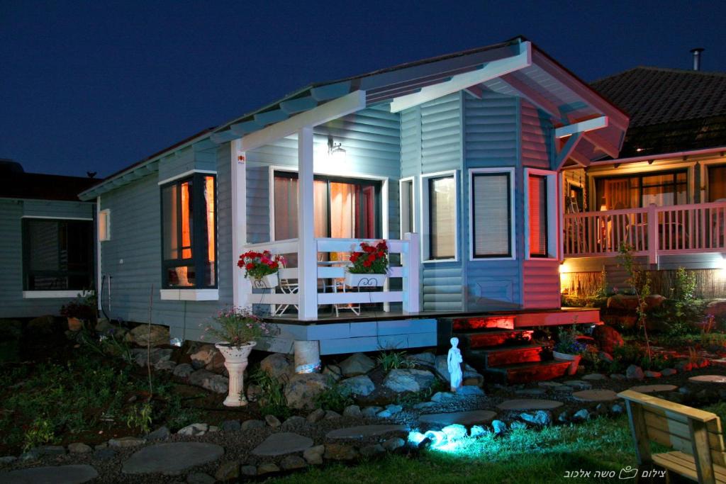 una pequeña casa azul con porche delantero por la noche en Villa Romantica, en Ani'am