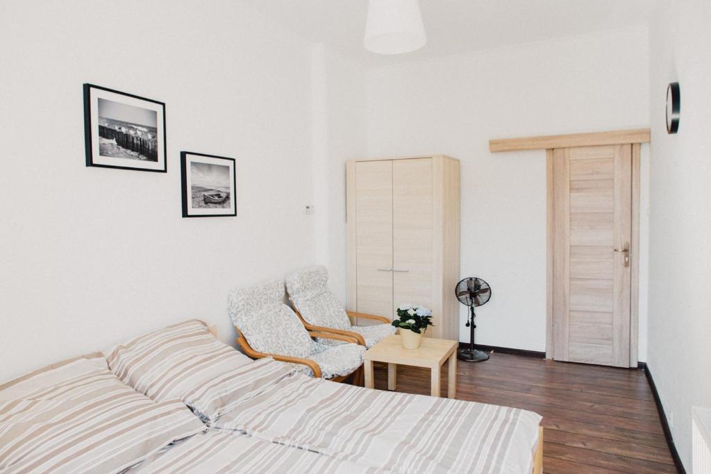 ソポトにあるApartament Sopot Sopotの白いベッドルーム(ベッド1台、椅子2脚付)