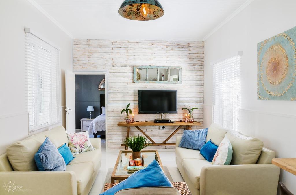 a living room with two couches and a tv at Mahdi Cottage in Swakopmund